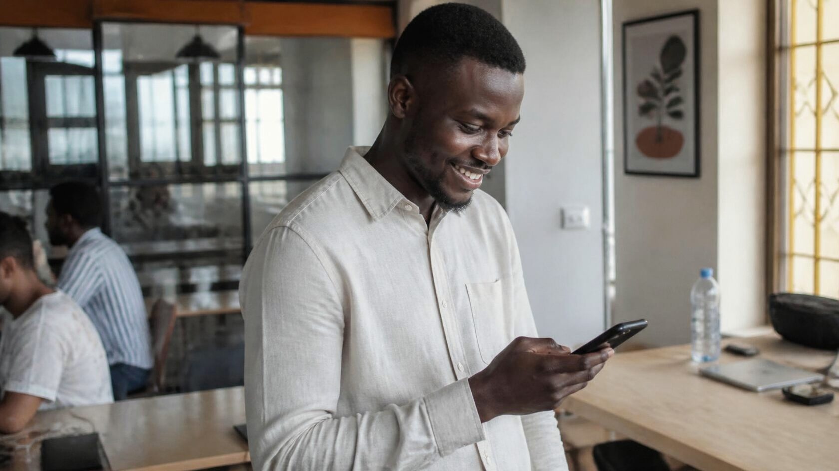 A man in an office reading his phone.